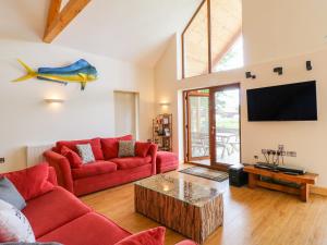 a living room with two red couches and a flat screen tv at Dorado Lodge in Lincoln