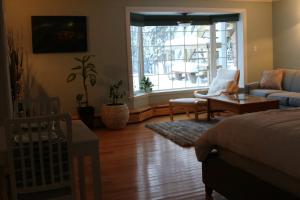 a bedroom with a bed and a living room at Great Slave Lakeside Bed & Breakfast in Yellowknife