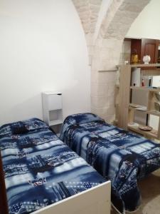 two beds sitting in a room with an arch at Casa Nino in Martina Franca