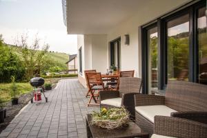 a patio with chairs and a grill and a table at Das Moseltor zu Koblenz in Lehmen