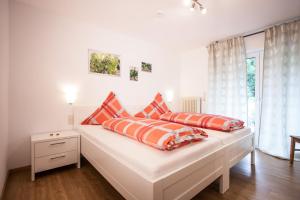 1 dormitorio con 2 camas y almohadas de color naranja y blanco en Das Moseltor zu Koblenz en Lehmen