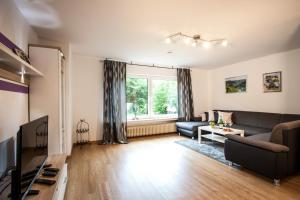 a living room with a couch and a tv at Das Moseltor zu Koblenz in Lehmen