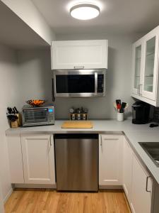 a kitchen with white cabinets and a microwave at Great Slave Lakeside Bed & Breakfast in Yellowknife
