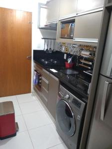 a small kitchen with a washing machine in it at Studio 15 - centro Campinas in Campinas