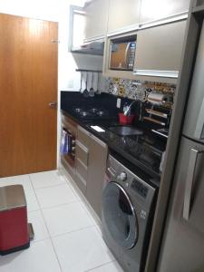 a small kitchen with a washing machine in it at The Flat 15 in Campinas