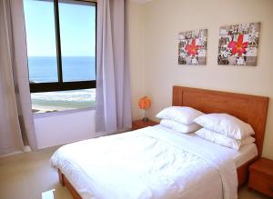sypialnia z łóżkiem i widokiem na ocean w obiekcie Almog Tower w mieście Hajfa