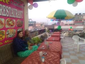 dos personas sentadas en mesas en un restaurante en Hotel Sai Palace Walking Distance From Taj Mahal--View of Taj Mahal, en Agra