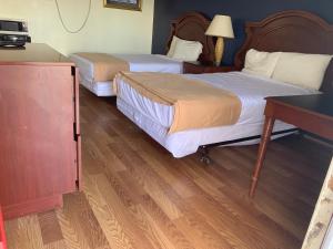Habitación de hotel con 2 camas y escritorio en Sunset Inn, en Atlantic City