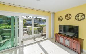uma sala de estar com uma televisão de ecrã plano e uma janela grande em King Bed - Walk to St. Armand's Circle and Lido Beach in Minutes! em Sarasota
