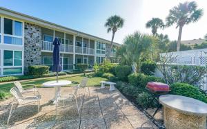Un patio con mesas y sillas frente a un edificio. en King Bed - Walk to St. Armand's Circle and Lido Beach in Minutes!, en Sarasota