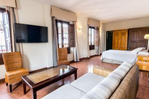 a living room with a couch and a bed at Hotel Plaza Nueva in Granada