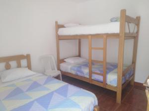 a bedroom with two bunk beds and a chair at El Buen Samaritano Backpackers in Paracas