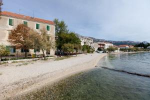 einen Strand mit Gebäuden und einem Wasserkörper in der Unterkunft Promaja in Kaštela