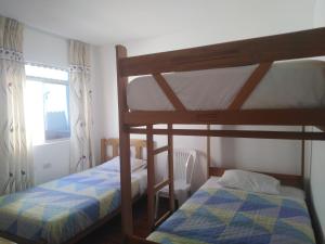 1 dormitorio con 2 literas y ventana en El Buen Samaritano Backpackers, en Paracas
