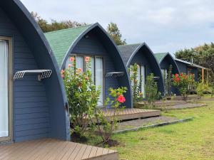 una fila de cabañas azules en un jardín en Rangi Moana, en Hanga Roa