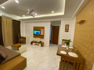 a living room with a dining table and a living room at Utsavam Hotel Apartments in Guruvāyūr