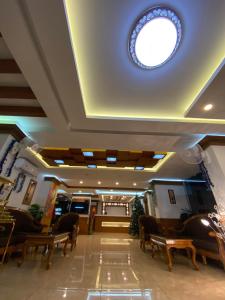 a lobby with benches and a round window on the ceiling at Utsavam Hotel Apartments in Guruvāyūr
