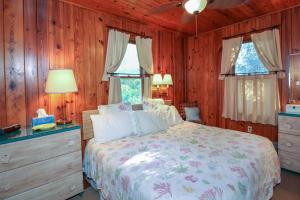 a bedroom with a bed and two windows at Bamboo Apartments in Holmes Beach