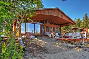 a wooden house with a porch and chairs in front of it at Newport Cabin with Lakefront Private Porch and Grill! in Newport
