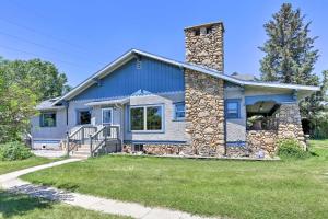 a blue house with a stone chimney at Walk to Downtown Custer Retreat with Fire Pit! in Custer