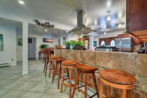 a kitchen with a bar with wooden stools at Expansive Getaway about 2 Miles to Mendenhall Glacier! in Mendenhaven