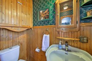 a bathroom with a white toilet and a sink at Walk to Lake Cabin with Deck and Views in Fawnskin in Fawnskin +16 photos