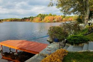 a wooden dock on a lake with a boat at Pond Access and Private Dock East Wareham Home in East Wareham