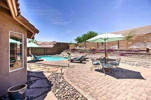 a patio with a table and an umbrella and a pool at Tucson Home with Pool and Santa Catalina Mtn Views in Tucson