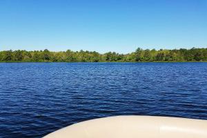 a boat on a large body of water at Pond Access and Private Dock East Wareham Home in East Wareham
