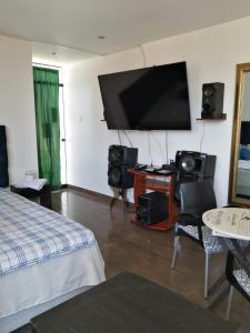 um quarto com uma cama e uma televisão de ecrã plano em Hospedaje Wankko em Huanchaco