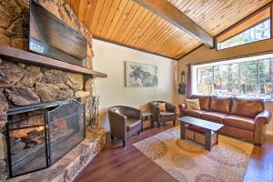 a living room with a large stone fireplace at Cozy Cabin with Deck and Fireplace in Big Bear! in Big Bear City