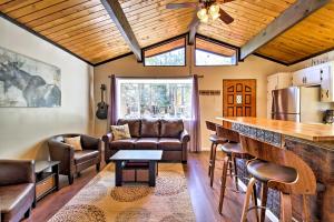a kitchen with a bar and a living room at Cozy Cabin with Deck and Fireplace in Big Bear! in Big Bear City