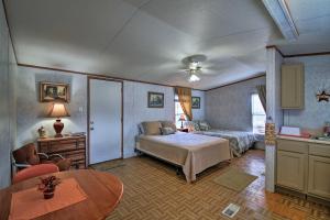 Schlafzimmer mit einem Bett und einem Tisch in der Unterkunft Quiet Utopia Cabin with Deck and Mountain Views! in Utopia