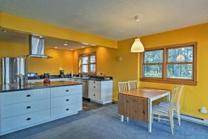 una cucina con pareti gialle e tavolo e sedie in legno di Spider Lake Cabin Boathouse, Canoe, Deck and Sauna! a Iron River