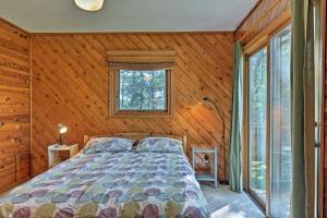una camera con un letto in una stanza con pareti in legno di Spider Lake Cabin Boathouse, Canoe, Deck and Sauna! a Iron River