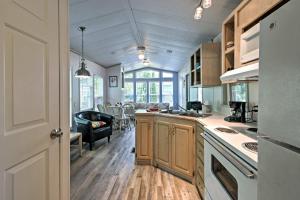 a kitchen with wooden cabinets and a living room at Middle Bass Island Home - Pool and Hot Tub Access! in Put-in-Bay