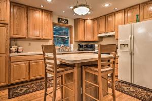 cocina con armarios de madera y nevera blanca en Pocono Mountain Home with 3 Community Lakes!, en Gouldsboro