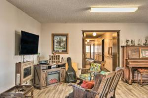 Una sala de estar con televisión y un piano. en HighPlaines Haven - Great Hunting and Fishing!, en Long Lake