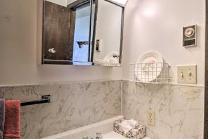 y baño con bañera y espejo. en HighPlaines Haven with Views, Hunting and Fishing!, en Long Lake 16 fotos más
