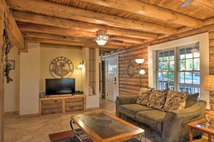 uma sala de estar com um sofá e uma televisão em Scottsboro Cabin with Fire Pit and Stocked Pond Access em Scottsboro