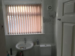 uma casa de banho com um lavatório, um WC e uma janela. em Holiday / vacation Double Room in Greater manchester em Summerseat