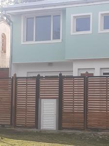 une maison avec une clôture en bois devant elle dans l'établissement Duplex Colina de Peralta Ramos, à Mar del Plata