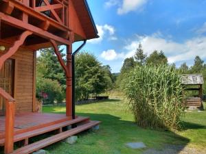 a wooden porch on a cabin in the grass at Leśniczówka Kalina in Wetlina