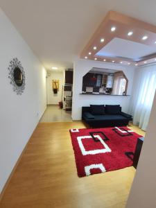 a living room with a couch and a red rug at 19 RESIDENCE apartment in Cavnic