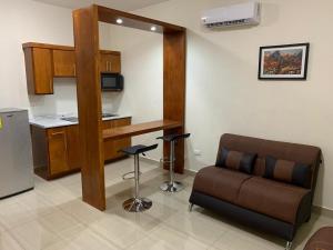 a living room with a couch and a kitchen at Palms Suites in Ciudad Acuña