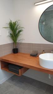 uma casa de banho com um lavatório e um espelho em Cameron Thermal Motel em Tauranga