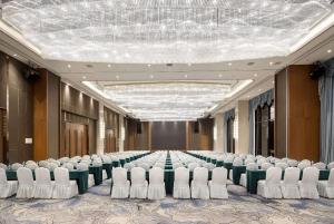 una sala conferenze con un lungo tavolo e sedie di Ramada Plaza by Wyndham Enshi a Enshi