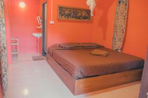 a bedroom with orange walls and a bed in a room at Chilling Hill Guesthouse in Pai
