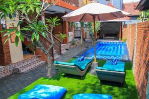 a swimming pool with chairs and an umbrella and a swimming pool at D'Tegal House in Nusa Lembongan