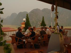 a group of people sitting at tables on a patio at Yen Nhi Hotel Ninh Binh in Ninh Binh